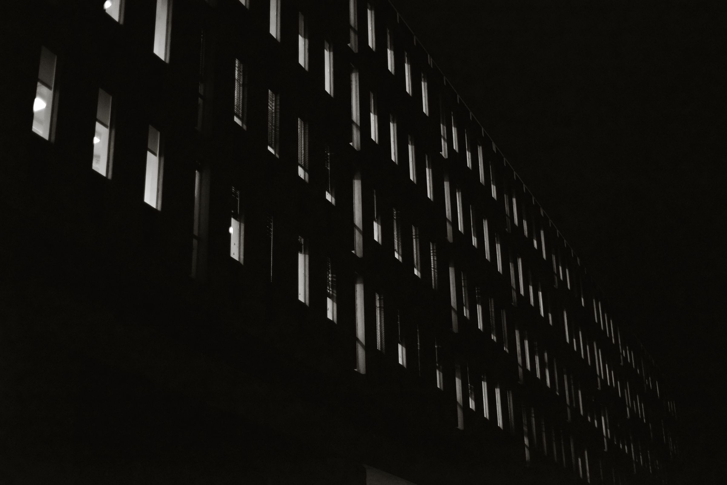 An office facade at night with a few lit windows